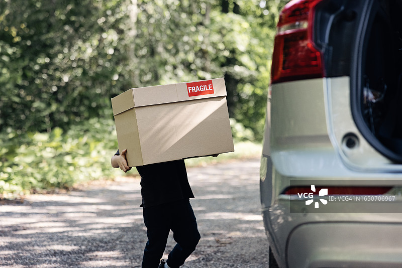 抱着纸箱的小男孩图片素材