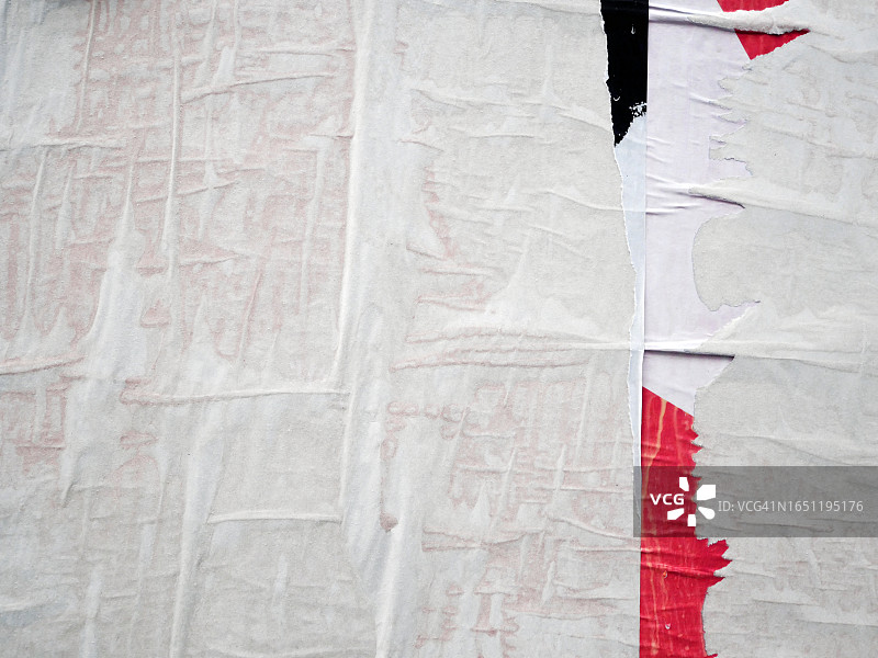 法国巴黎墙上粘贴和撕毁的白色、黑色和红色海报特写图片素材