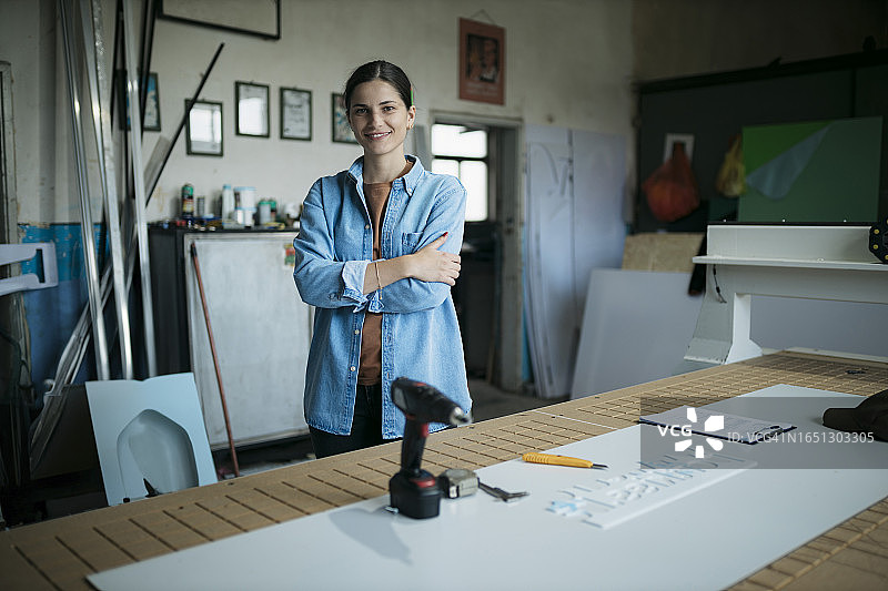 在标牌制造部门工作的自信年轻女性肖像图片素材