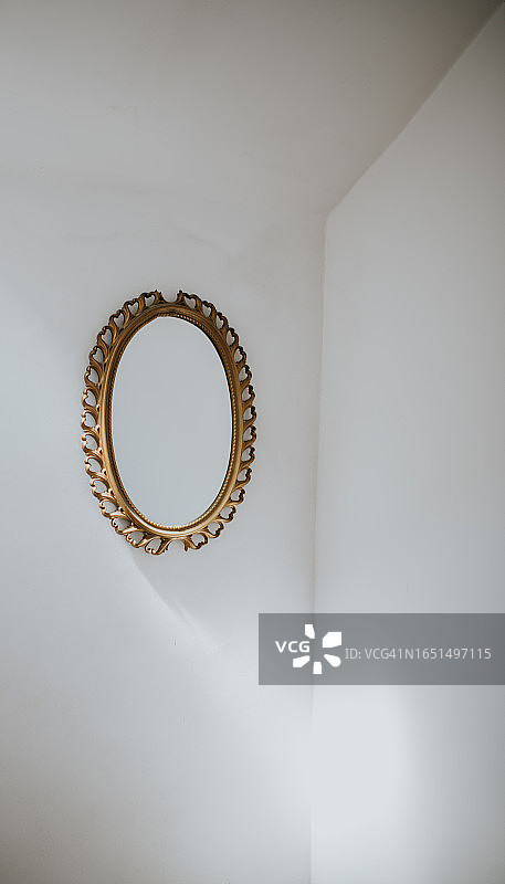 安装在白色墙壁上的椭圆形镜子的简约图像图片素材