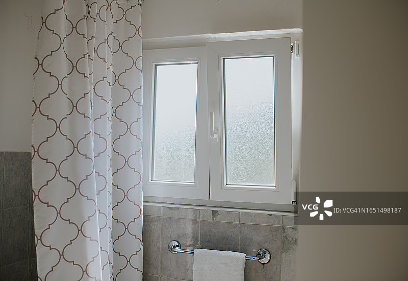 浴室里一扇带磨砂玻璃的PVC窗户半开着图片素材