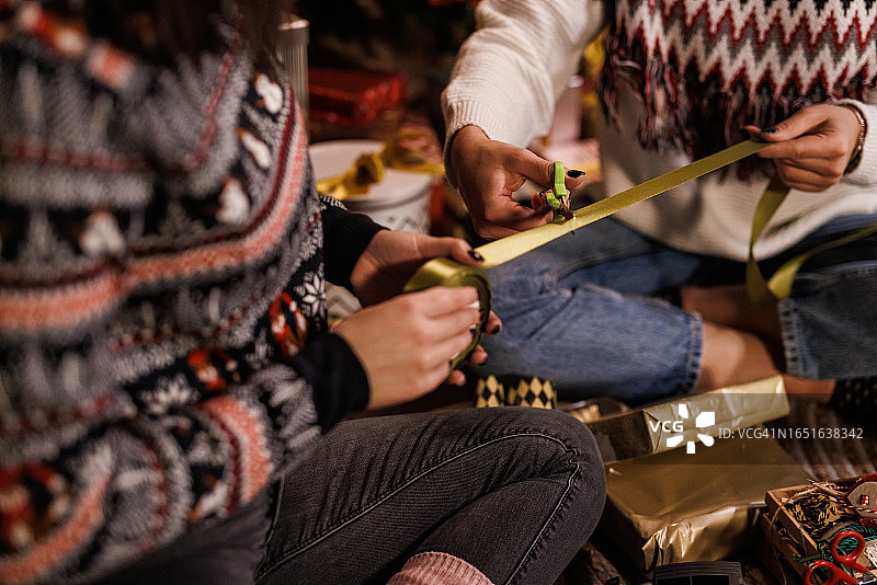 女友们剪裁金色丝带装饰圣诞礼盒图片素材