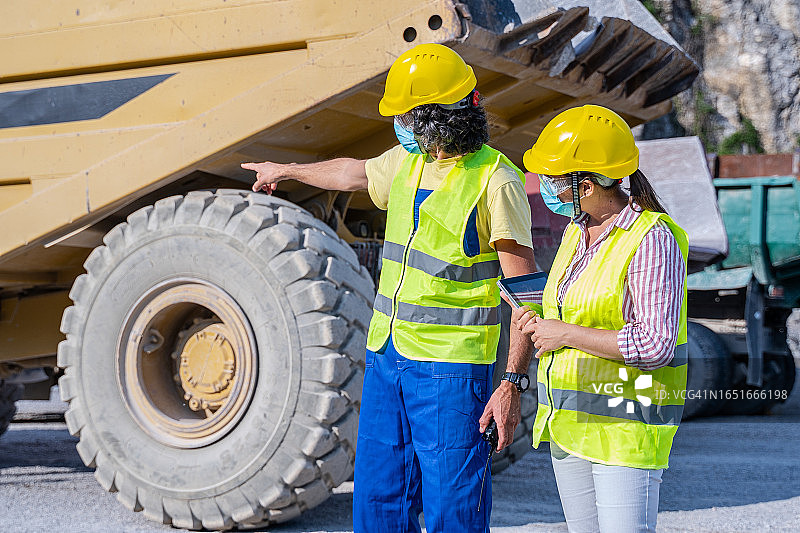 佩戴防护口罩的道路工程师正在工作图片素材