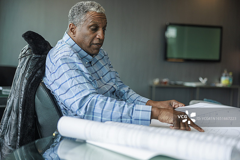 专注的商人在现代办公室阅读技术图纸图片素材