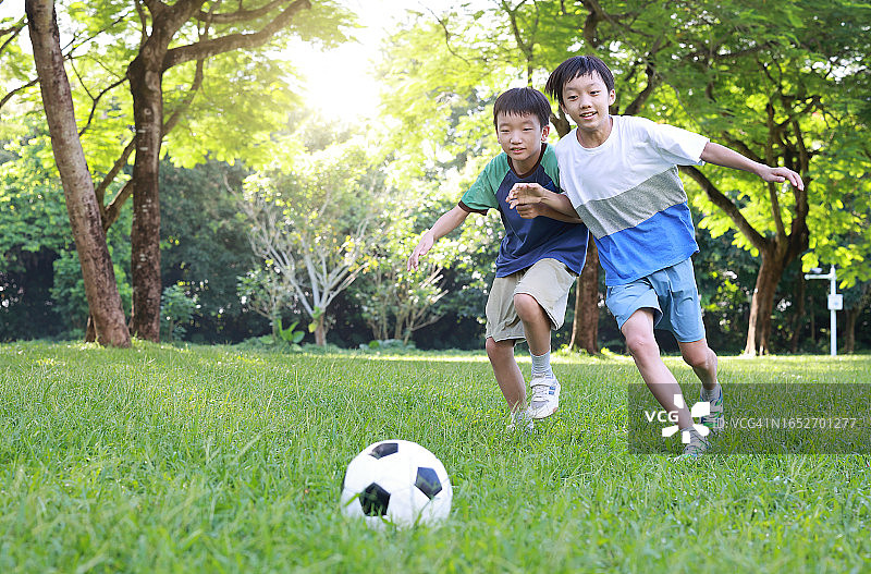 在公园里踢足球的小男孩图片素材