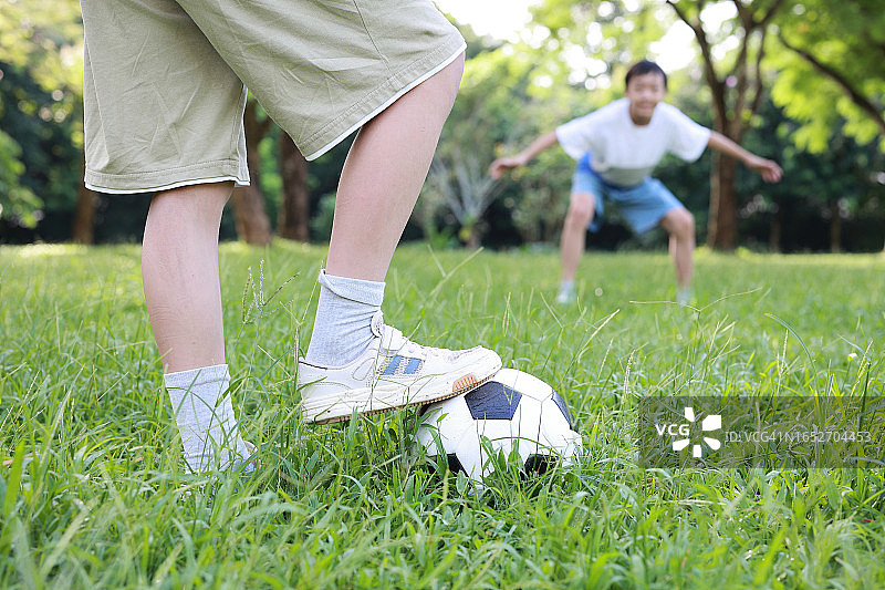 在公园里踢足球的小男孩图片素材
