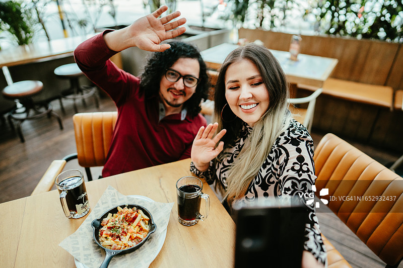 朋友们在餐厅自拍或拍摄图片素材