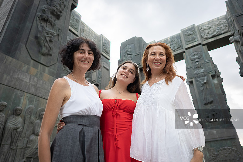 在历史遗迹中快乐的中年妇女和她们的女儿们的合影图片素材