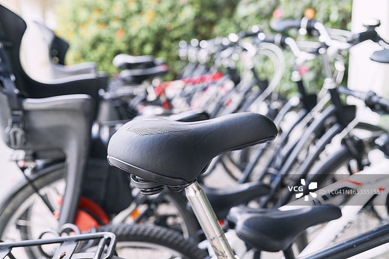 停在街上的一排自行车的车座特写，侧视图图片素材