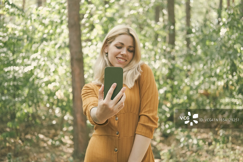 年轻女子在阳光明媚的户外自拍图片素材