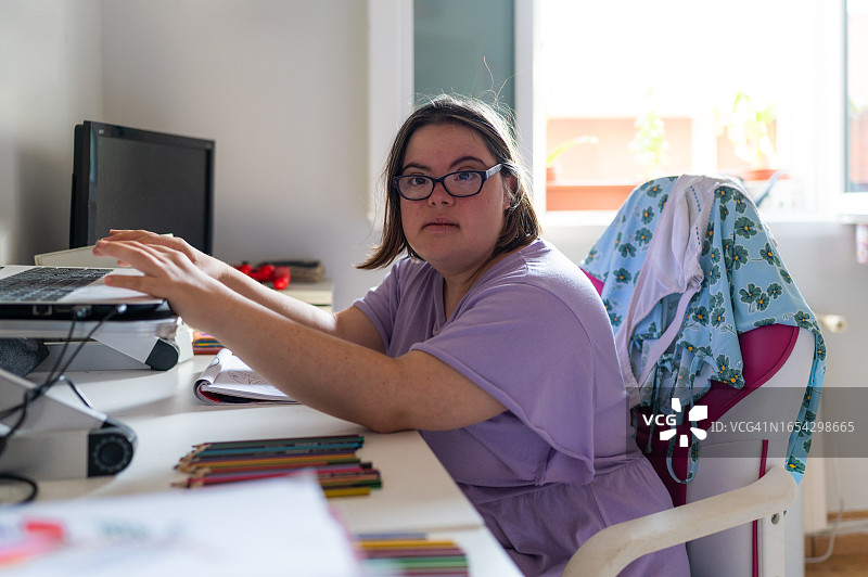 患有唐氏综合征的女子在家使用笔记本电脑图片素材