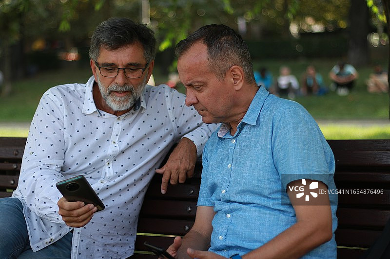 两位年长的商人在长椅上谈论工作图片素材