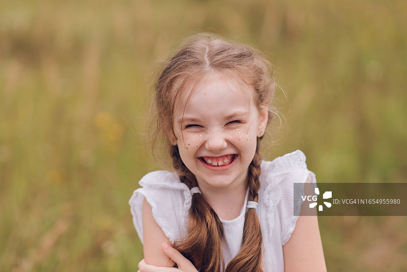 七岁金色雀斑双马尾女孩的微笑肖像图片素材