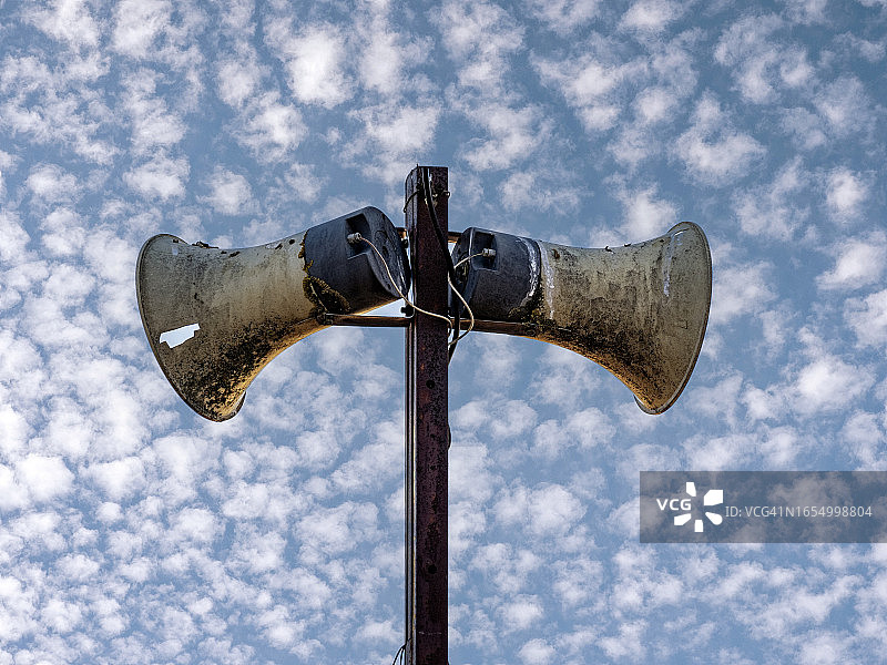 日落时分多云蓝天下的公共广播扬声器图片素材