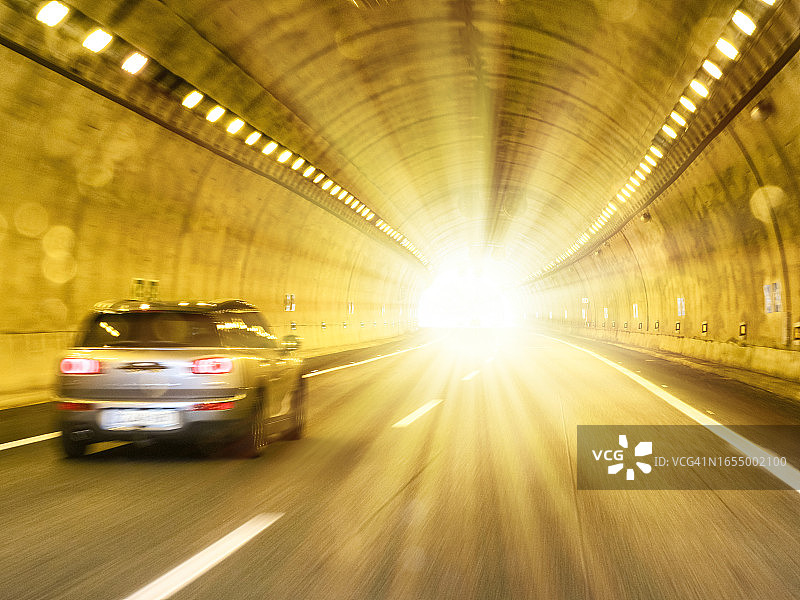 汽车在隧道中行驶，隧道尽头闪着光芒图片素材