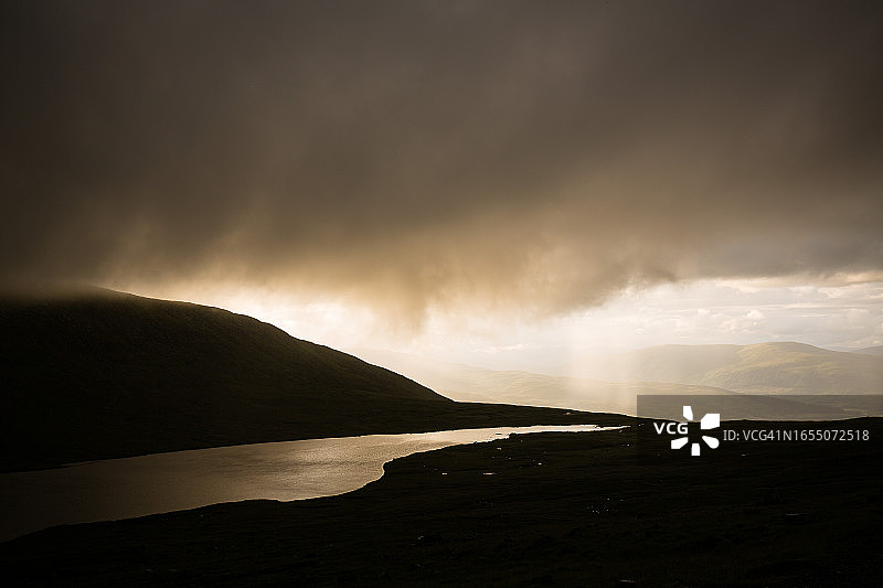 光线强烈、乌云密布的山脉图片素材