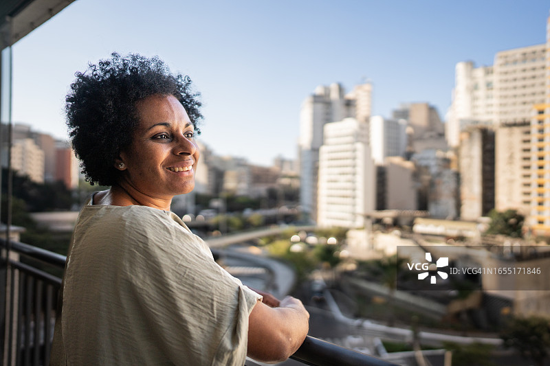 中年妇女在公寓阳台上沉思图片素材
