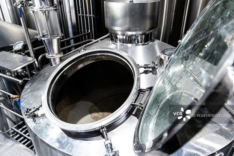 啤酒厂中打开的啤酒生产机器特写图片素材