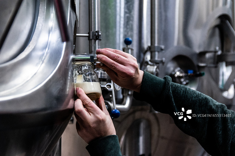 啤酒厂工人倾倒啤酒特写图片素材