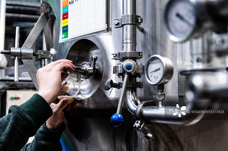 啤酒厂工人倾倒啤酒特写图片素材