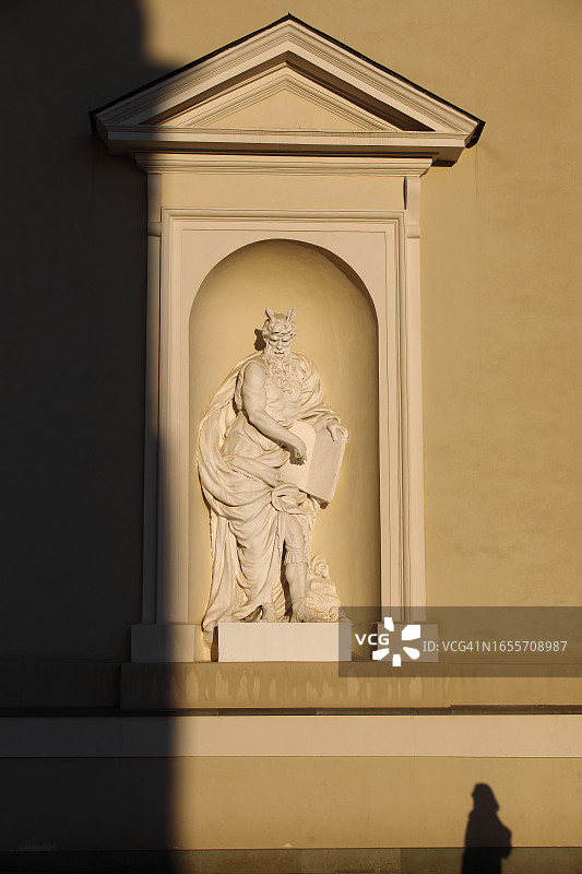 大教堂外墙上的大型雕像与游客的影子图片素材