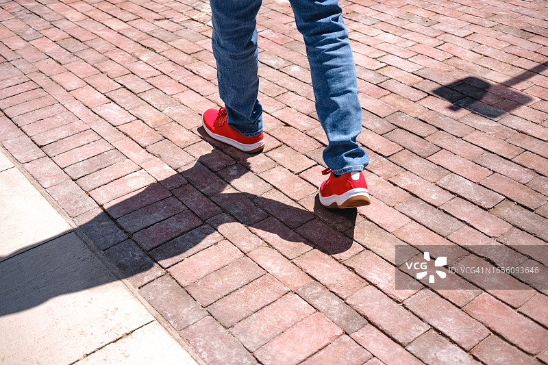 男子穿着蓝色牛仔裤和红色鞋子去散步图片素材