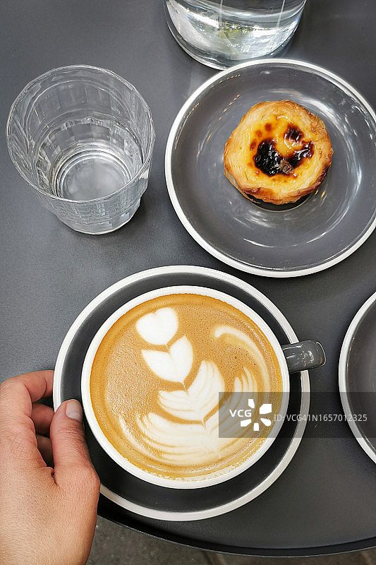 一杯卡布奇诺和葡式蛋挞图片素材