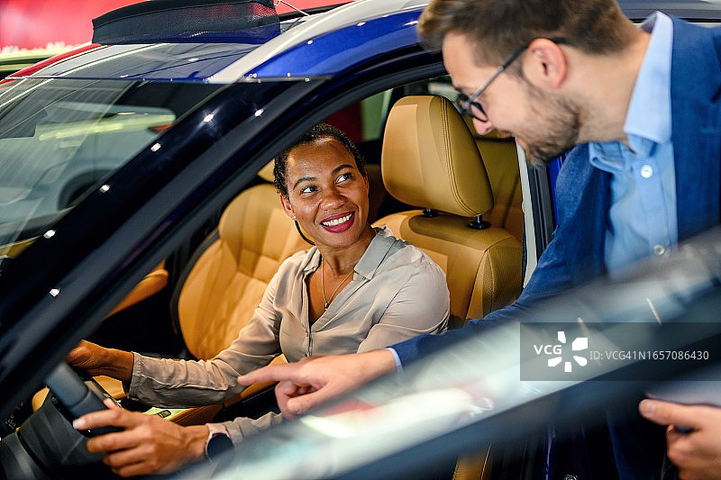 商人帮助男顾客选择新车图片素材