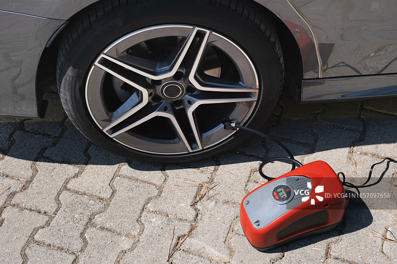 小型充气泵给汽车轮胎充气特写图片素材