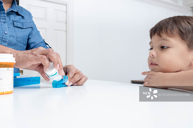 小男孩看着奶奶整理药物图片素材