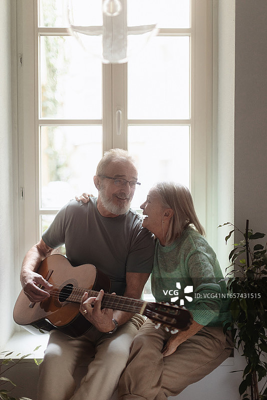 年长的男人为妻子弹奏浪漫的吉他曲图片素材