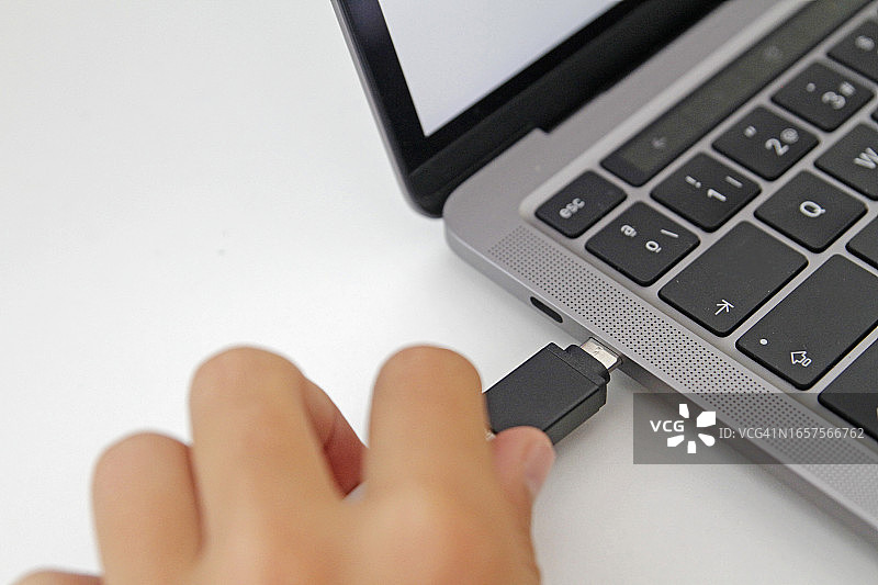 一个人将USB存储器插入笔记本电脑图片素材