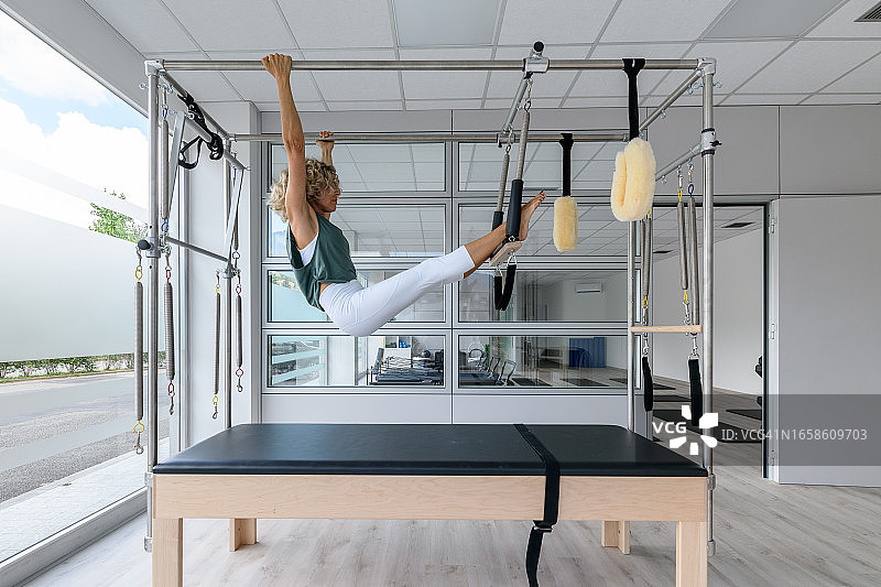 普拉提工作室：教练在吊架训练器上图片素材