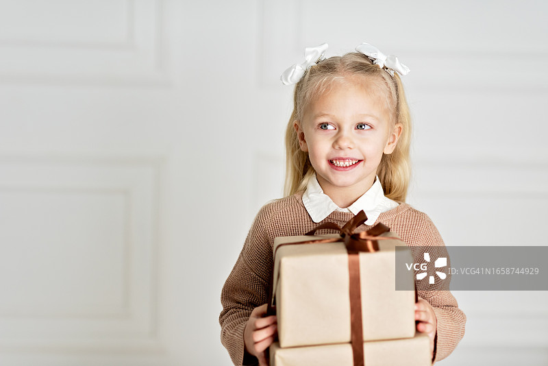 圣诞快乐，节日快乐！拿着礼品盒的有趣女孩。图片素材