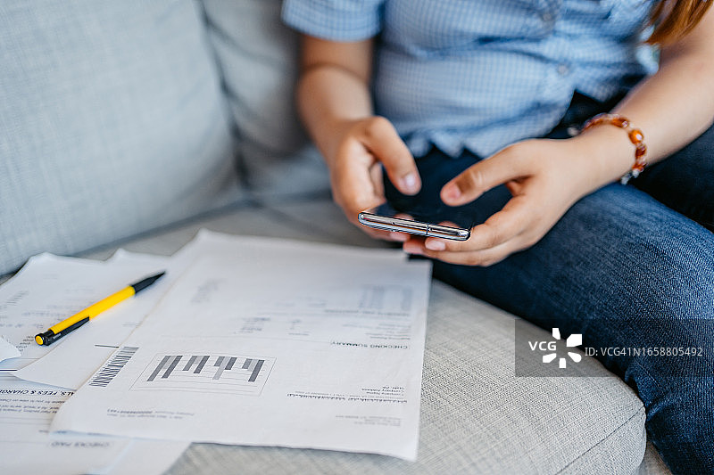 年轻女人用智能手机查看财务状况图片素材