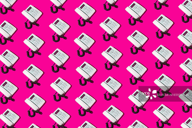 粉色背景上的白色复古电话图案，旧式电话有线电话客服概念图片素材