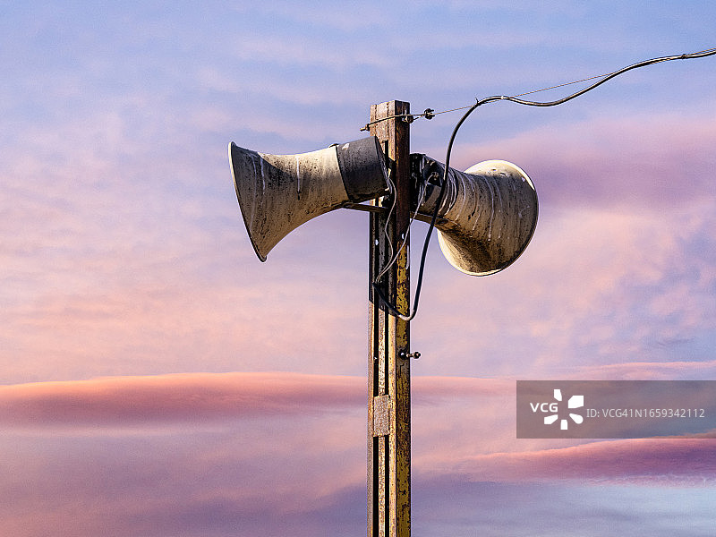 日落天空下的公共广播系统扬声器图片素材