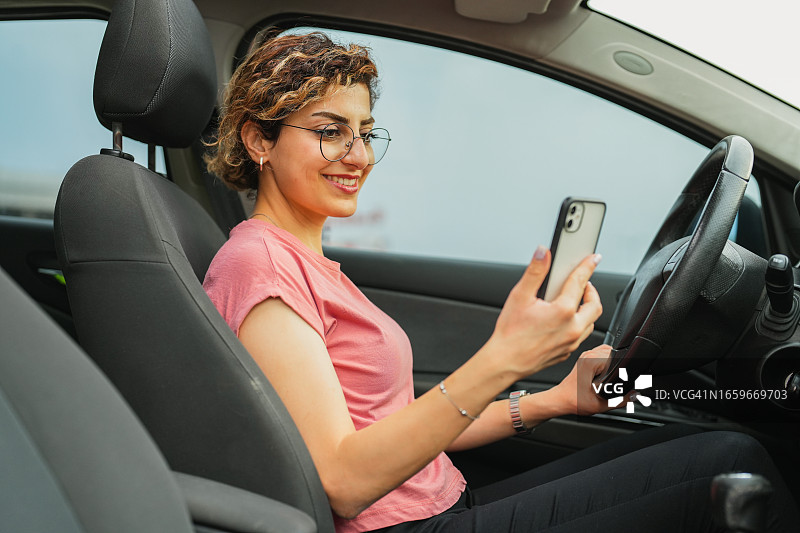 年轻女人开车时用手机自拍图片素材