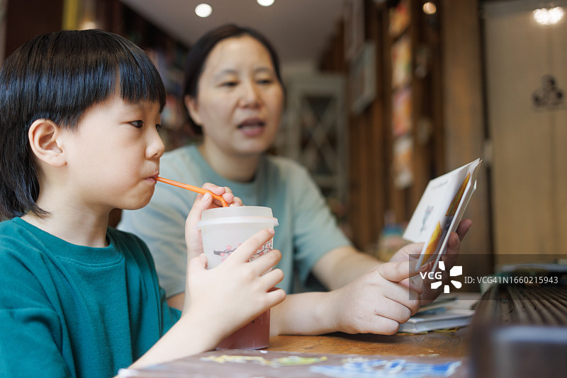 亚洲妈妈和儿子在书店阅读图片素材