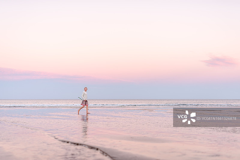 在美丽海滩上穿裙子的少女图片素材