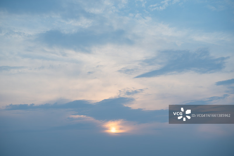 蓝色云层后的太阳，空灵的粉彩自然背景图片素材