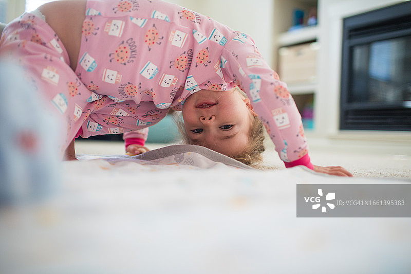 在家中客厅倒立玩耍的年轻女孩图片素材