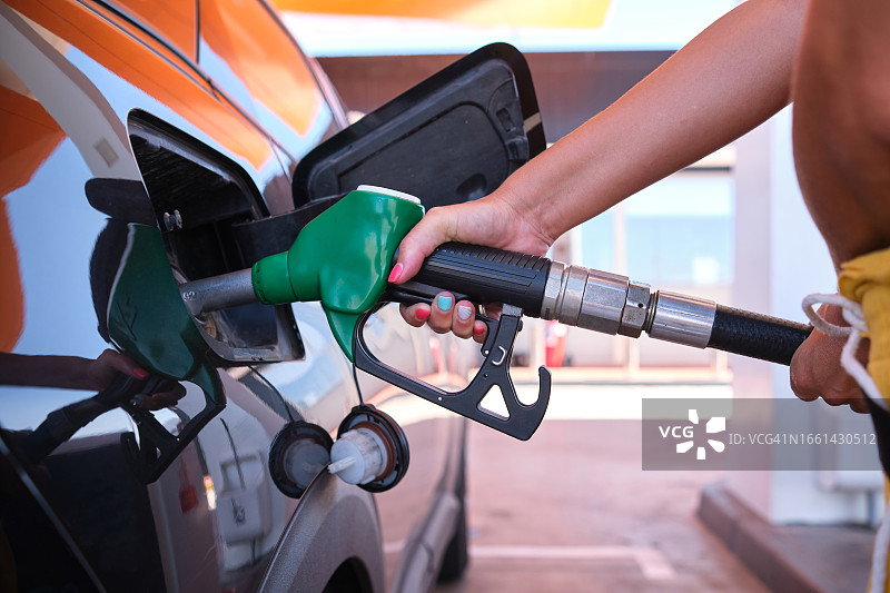 石油危机导致柴油和汽油价格上涨 - 一名妇女正在加油图片素材
