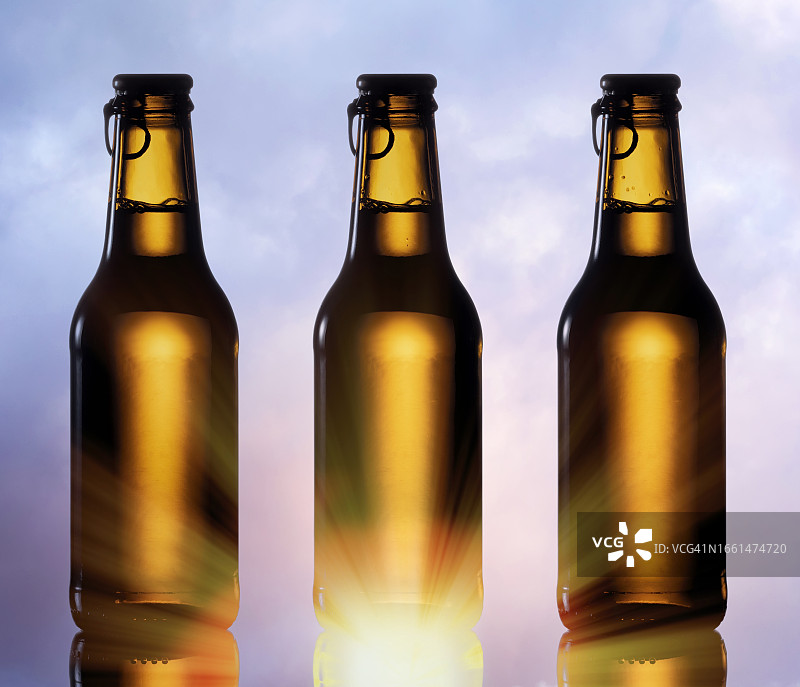 夕阳天空下的冰镇啤酒瓶图片素材