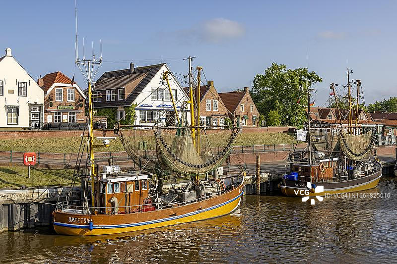 格里茨希尔港口的捕蟹工具和蟹网，背景是历史建筑，德国下萨克森州图片素材