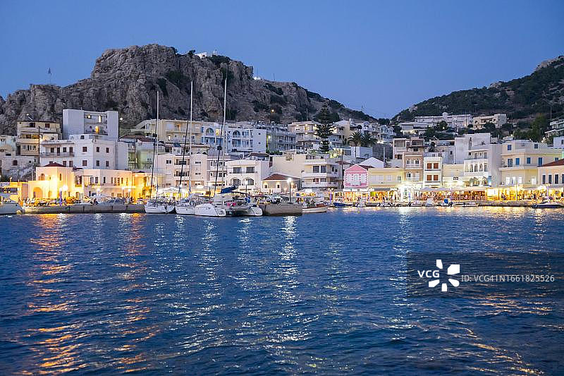 希腊多德卡尼斯群岛卡尔帕索斯岛，傍晚皮加迪亚灯火通明的港口城市图片素材