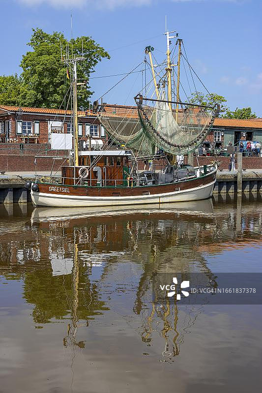 德国下萨克森州格里特希尔港口水中倒影的捕蟹船图片素材