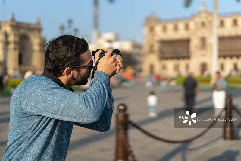 男摄影师在城市旅游中心拍照图片素材