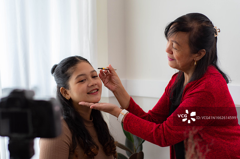 东南亚裔中年女性和年轻女性正在拍摄美妆教学的社交媒体内容图片素材