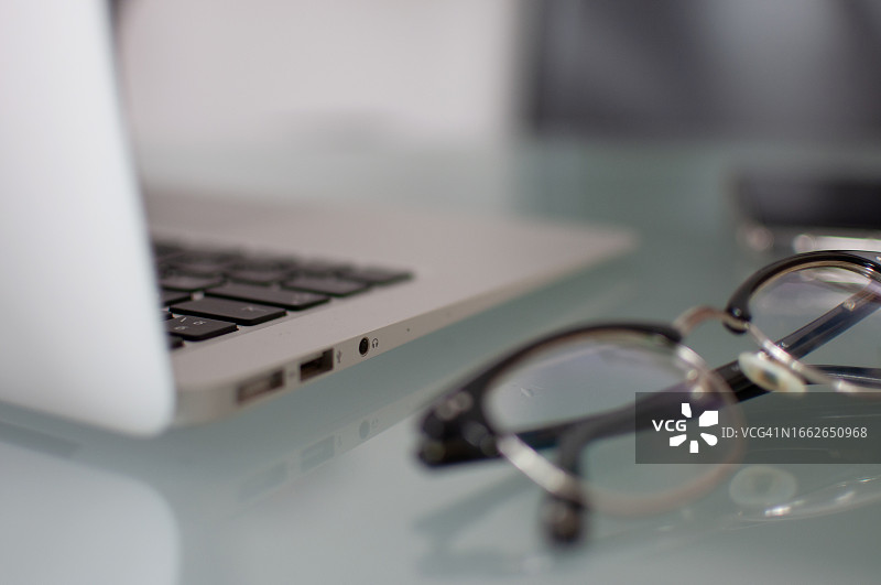 桌子上眼镜和笔记本电脑的特写镜头图片素材